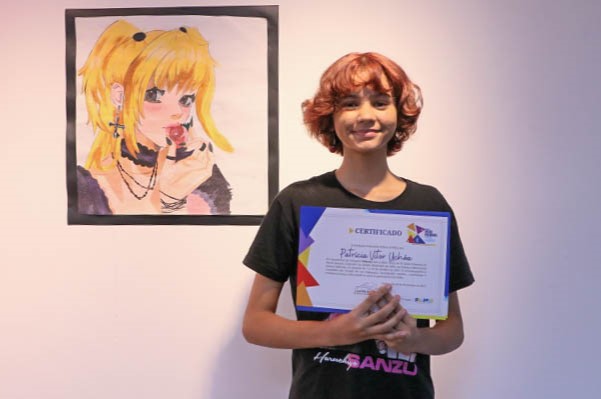 Patrícia Uchôa ao lado de sua obra de técnica mista ‘Misa’, que a levou ao título na categoria Infantil